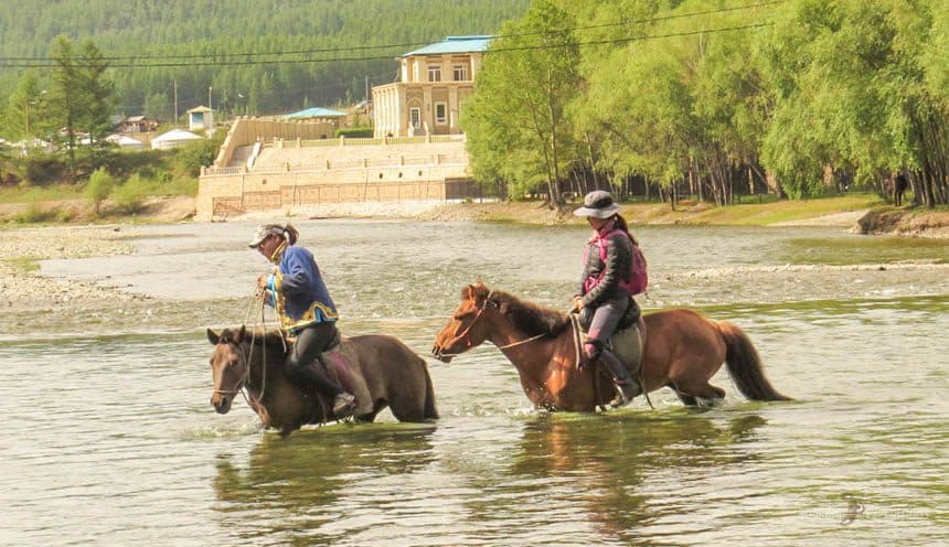 Riders crossing a river on horseback